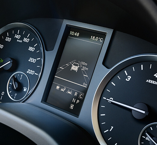 The dashboard of a Mercedes-Benz Cargo Van displaying a visual warning from the Active Brake Assist safety feature. 