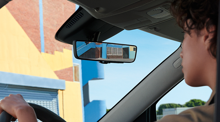 We see a woman driving utilizing the Digital Interior Mirror feature in the Mercedes-Benz Vans Metris Cargo Van. 
