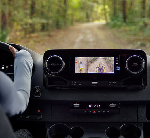 A person driving a Mercedes-Benz Adventure Van in reverse gear using the 360° Camera.