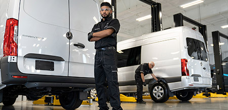 Mechanic standing at the back of a Mercedes-Benz Van.