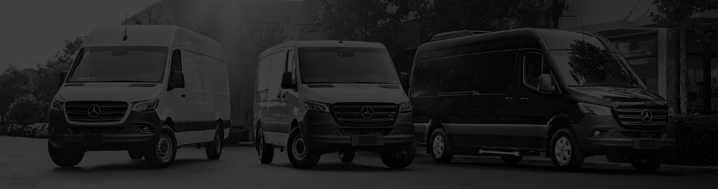 Group of Mercedes-Benz Sprinter Vans parked along a streetscape.